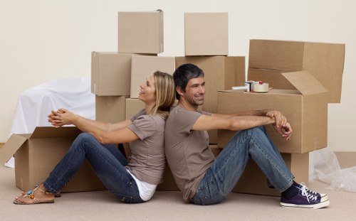Careful wrapping of fragile household items during a Harrow packing service