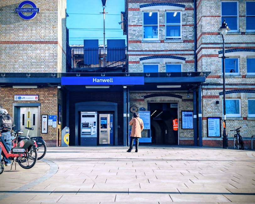 Two removal crew members from Self Storage Harrow are engaged in packing and loading large cardboard boxes onto a moving trolley during a house relocation. The team is working outdoors next to a large